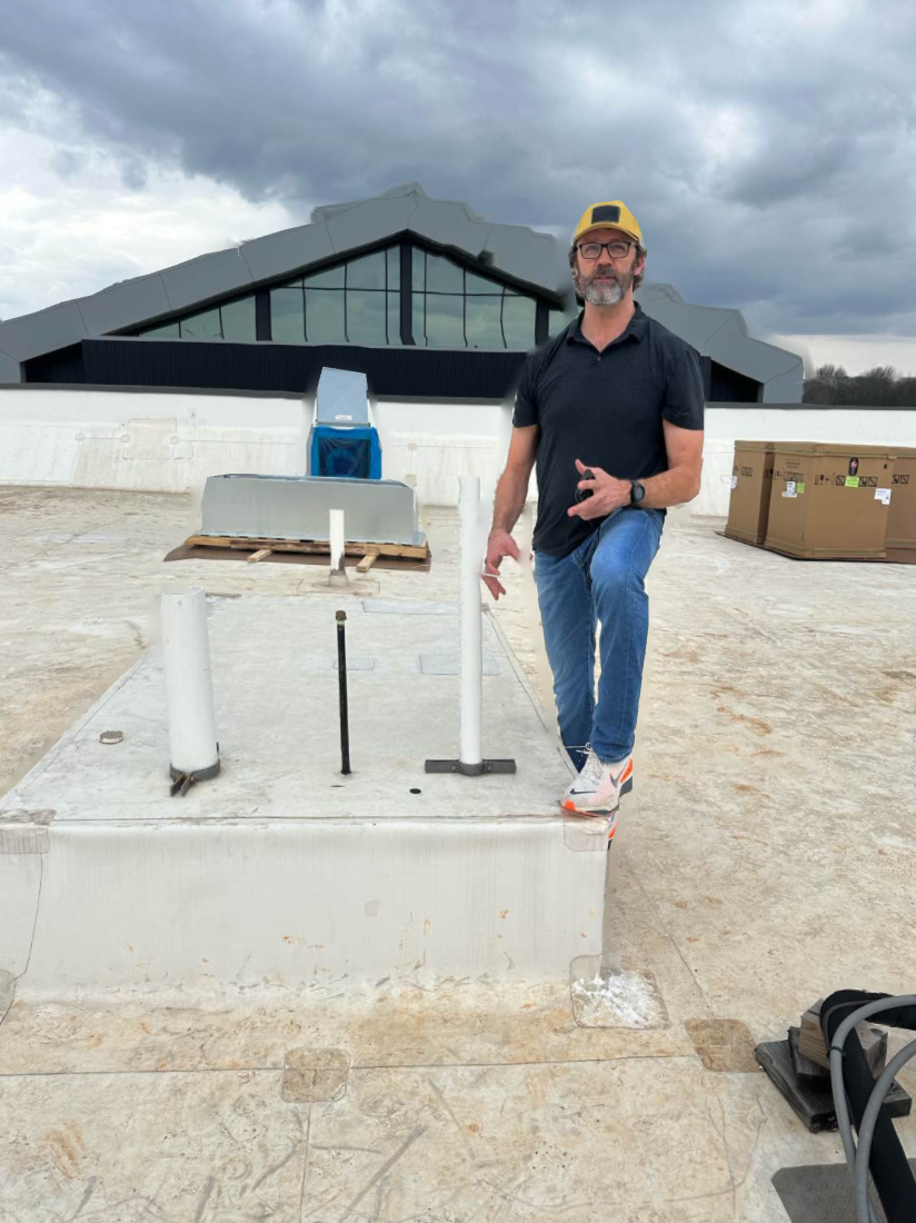 Gary of Saturn 5 Roofing inspecting rooftop equipment curbs on a commercial building